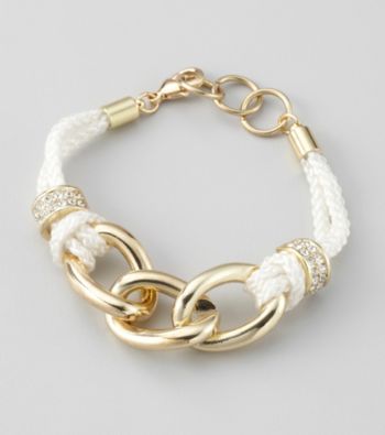 White rope tied with slip knots and set with simulated crystal pave charms suspend goldtone links in this nautical bracelet by GUESS.