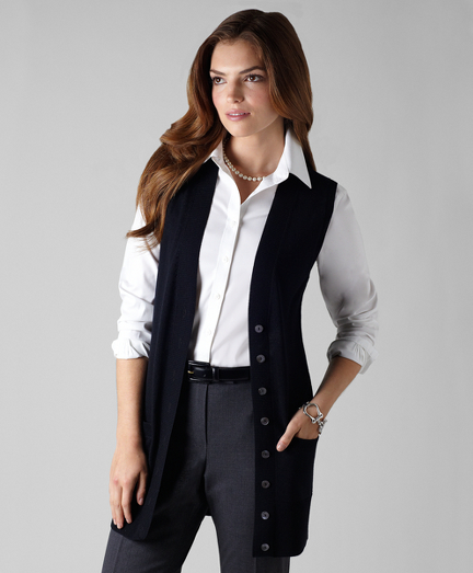 Extrafine Italian merino wool. Jersey stitch elongated vest. Rib trim at cuff, placket and bottom hem. Mother-of-pearl buttons. Dry clean. Imported.