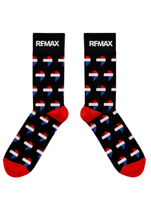 Black crew socks with red heels and toes, decorated with a repeating red, white, and blue RE/MAX balloon pattern and featuring the white RE/MAX logo at the top.