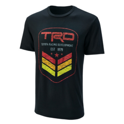 A black T-shirt with a large emblem featuring 'TRD' in bold red letters, 'Toyota Racing Development,' three downward-pointing chevrons, and 'EST 1979.