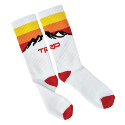 White socks with red toes and heels, featuring sunset-colored stripes and a black silhouette of mountains with 'TRD' in red.