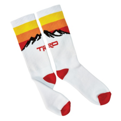 White socks with red toes and heels, featuring sunset-colored stripes and a black silhouette of mountains with 'TRD' in red.