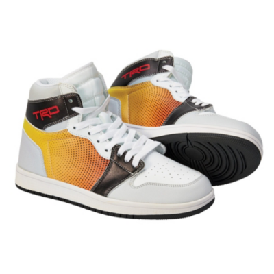 A pair of high-top sneakers with a white base color, featuring yellow and orange gradient perforated side panels, black accents on the toe cap and heel, and 'TRD' branding in red on the outer side near the ankle.