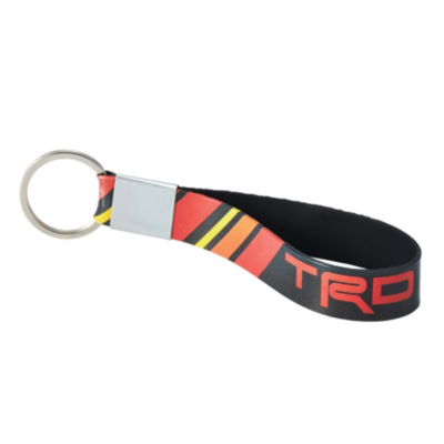  keychain with a metal ring and a looped strap. There is a red, yellow, and black striped pattern on the outside. The letters 'TRD' are printed in red on the black section of the strap near the metal ring