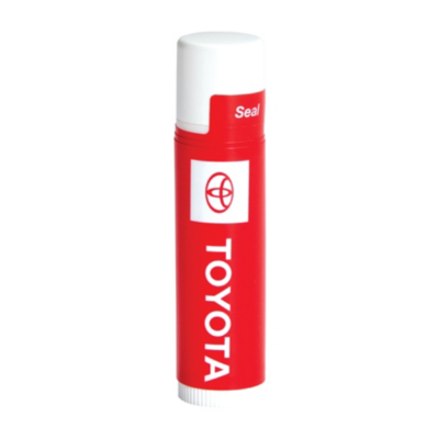 A red cylindrical container of lip balm, labeled with a rectangular label with a red logo and the word 'TOYOTA' written vertically in white letters.