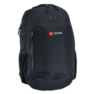 Black backpack with multiple compartments and zippers. Features a red patch with the Toyota logo and embossed 'OGIO' brand name. Mesh pockets on the sides.
