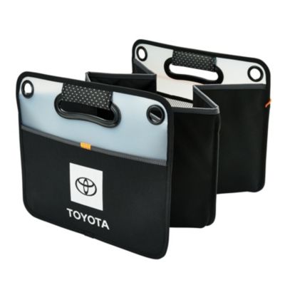A black and gray collapsible storage organizer with three compartments, featuring the Toyota logo on the front. The organizer has two handles with reinforced grommets.