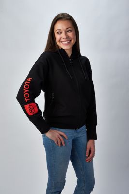 Person wearing a black zip-up hoodie with red 'TOYOTA' text and logo on the left sleeve,