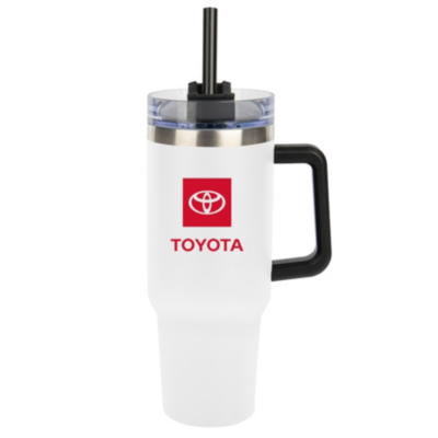 A white travel mug with a black handle and a clear lid featuring a black straw. The mug has the Toyota logo with the word ""TOYOTA"" written below in red
