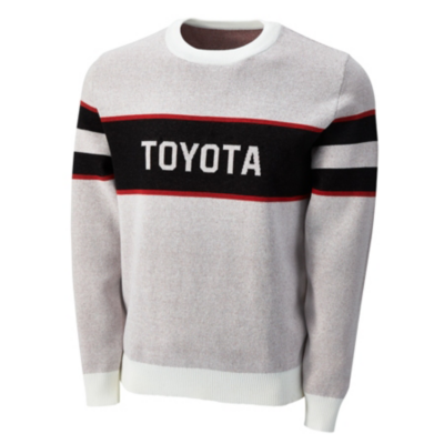 A light gray sweater with a white collar and cuffs. The sweater features a black horizontal stripe across the chest with the word 'TOYOTA' in bold white letters, flanked by thinner red stripes