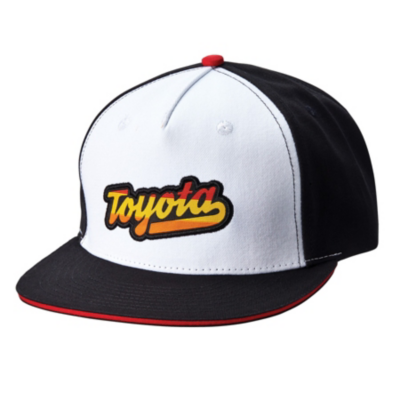 A black and white baseball cap with a red button on top. The front panel is white with the word 'Toyota' embroidered in a stylized font, featuring a gradient from yellow to red. The brim of the cap is black with a thin red edge