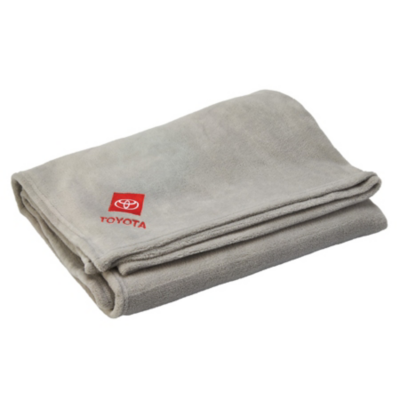 A light gray fleece blanket with Toyota stacked logo in red embroidered on corner