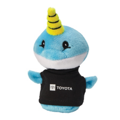 A plush toy of a blue narwhal with a yellow and black striped horn. The narwhal has a white belly, small flippers, and is wearing a white shirt with red Toyota logo