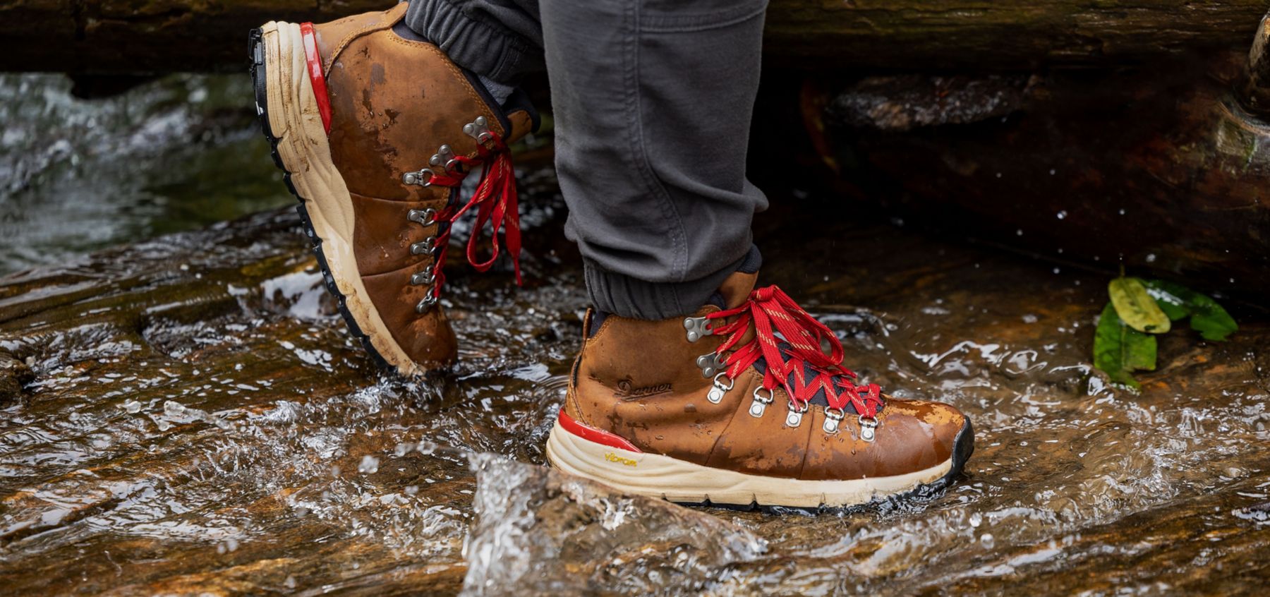 brown and red hiking shoes crossing a stream