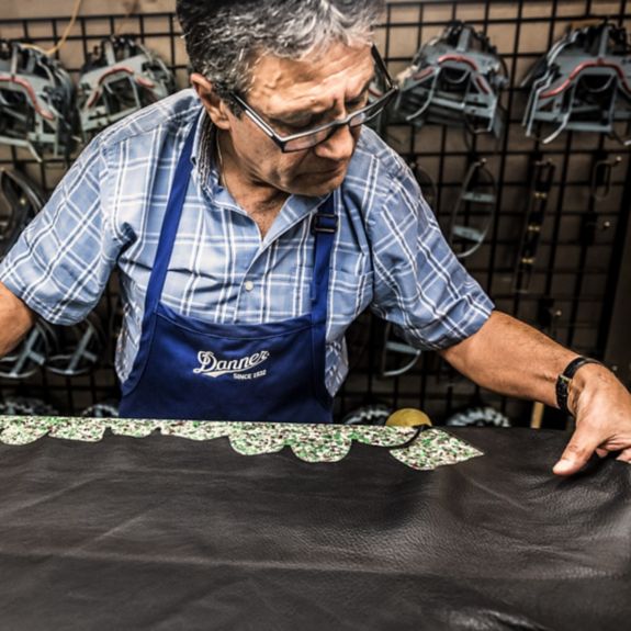 Boot maker inspecting a leather hide for quality.