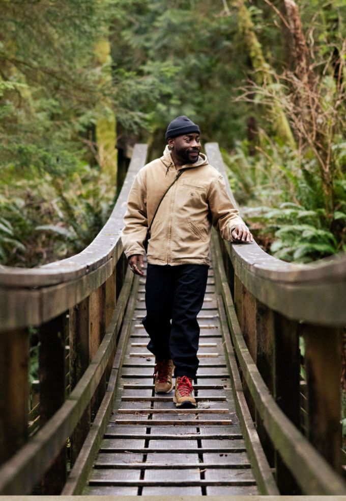 man walking across a wooden suspension bridge