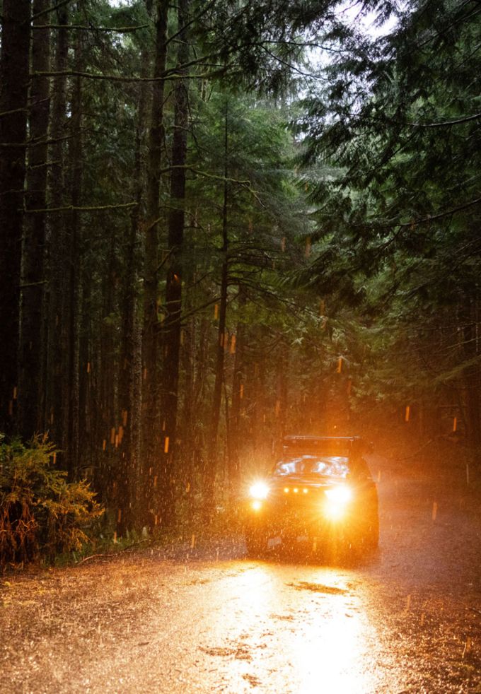 vehicle driving through the rain on a logging road