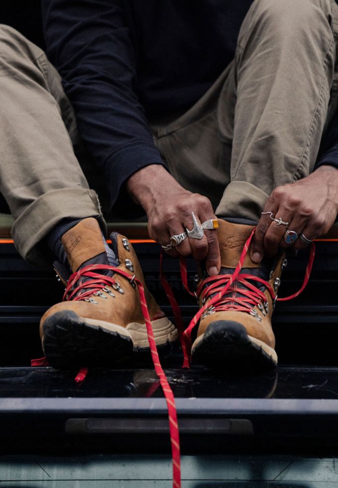 tying a pair of brown and red hiking boots