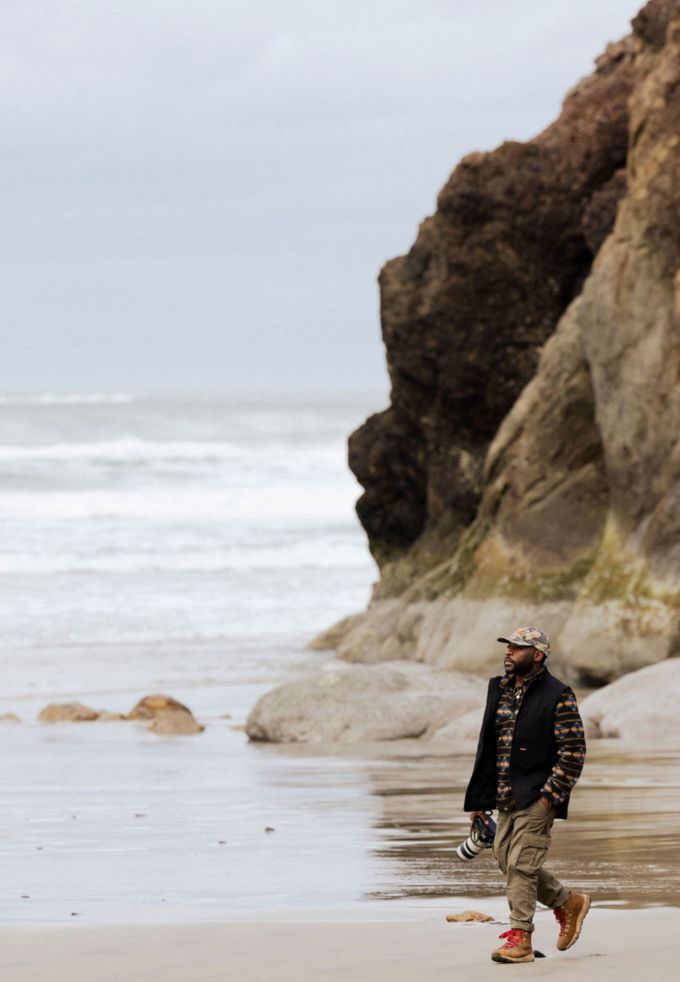 man hiking with camera on beach