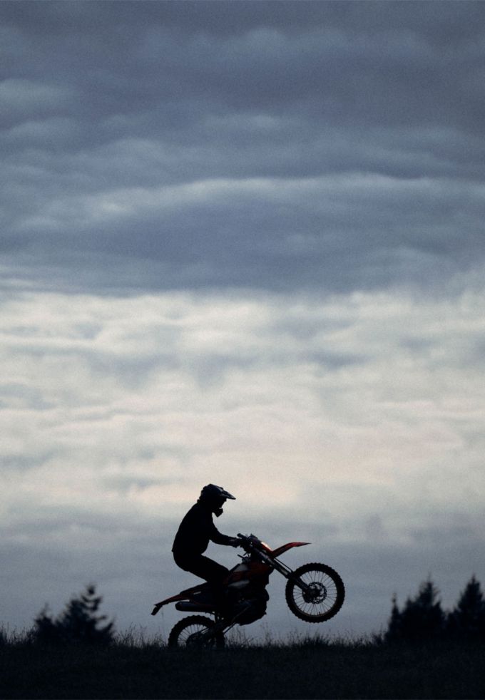 man on motorcycle against clouds