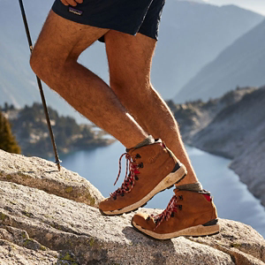 a pair of brown work boots with orange accents