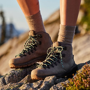 a pair of brown work boots with orange accents