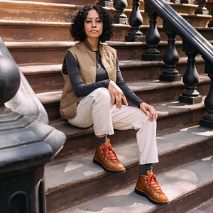 a pair of brown work boots with orange accents