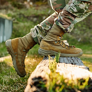 a pair of brown work boots with orange accents