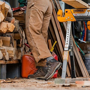 a pair of brown work boots with orange accents