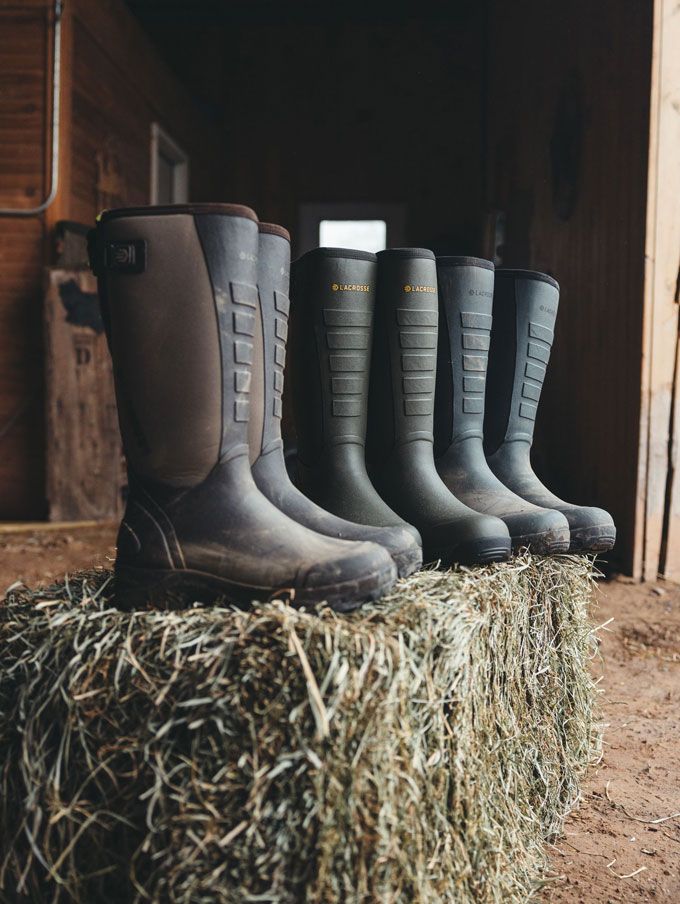 A stone colored pair of ankle high rubber boots is shown getting into a vehicle