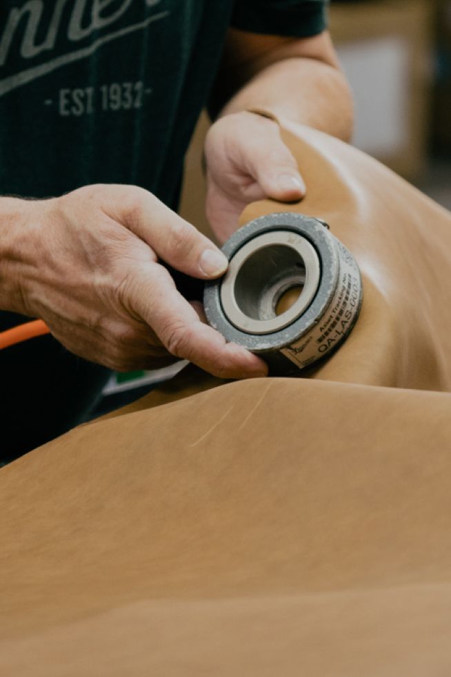 A man is using a computer to design a pair of Danner Boots.