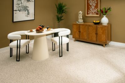 A dining room with light beige carpet with orange accents