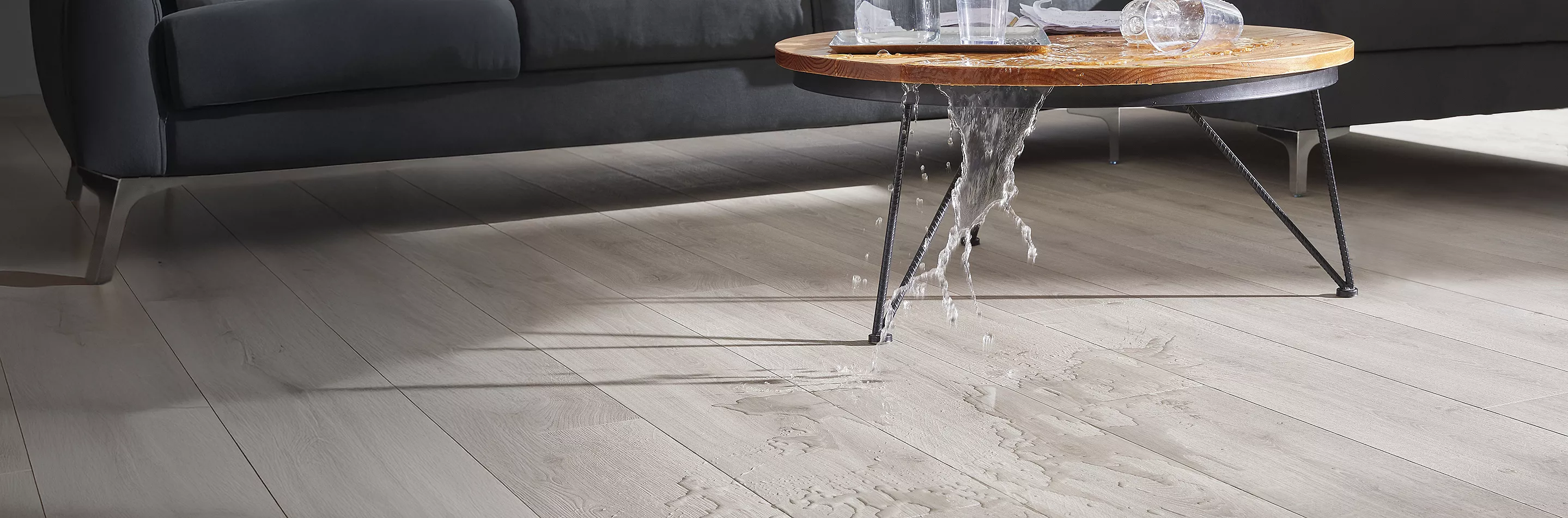 Wet feet on top of flooring with a towel being held