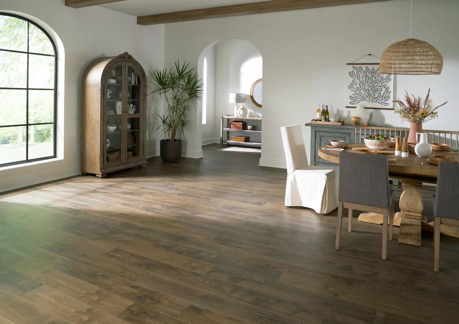 Warm wood-look vinyl flooring in a dining room with arched windows and upholstered chairs