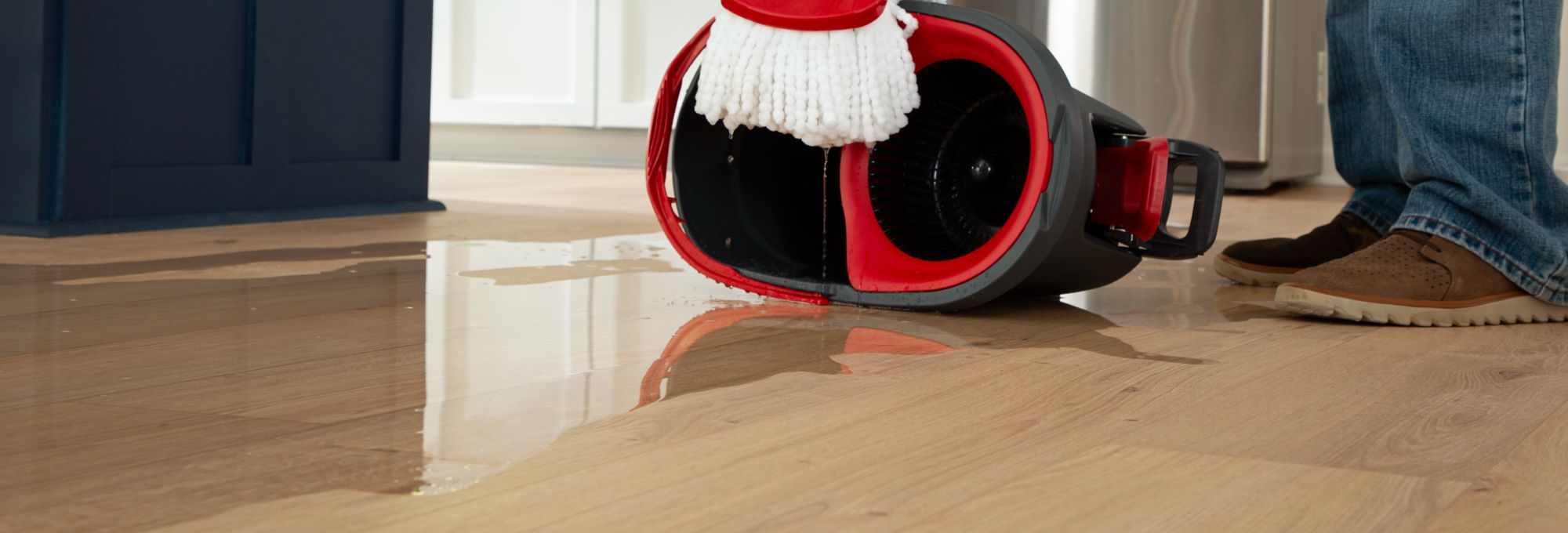 water bucket spilling onto a hardwood floor