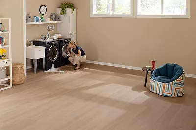 girl having a tea party with a toy rhino wearing a pearl necklace