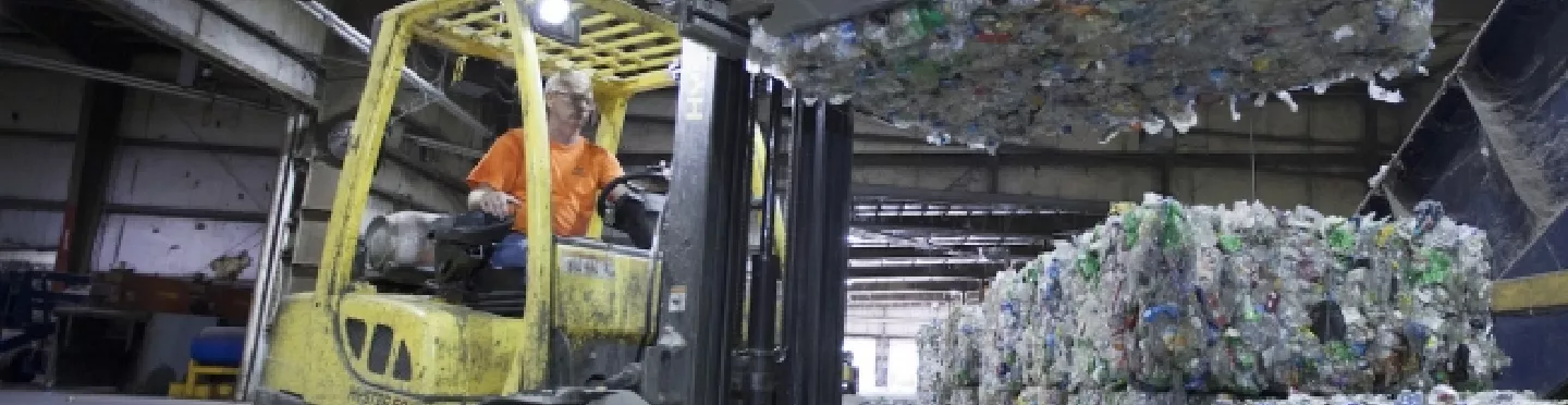 Forklift lifting plastic bottles to be recycled