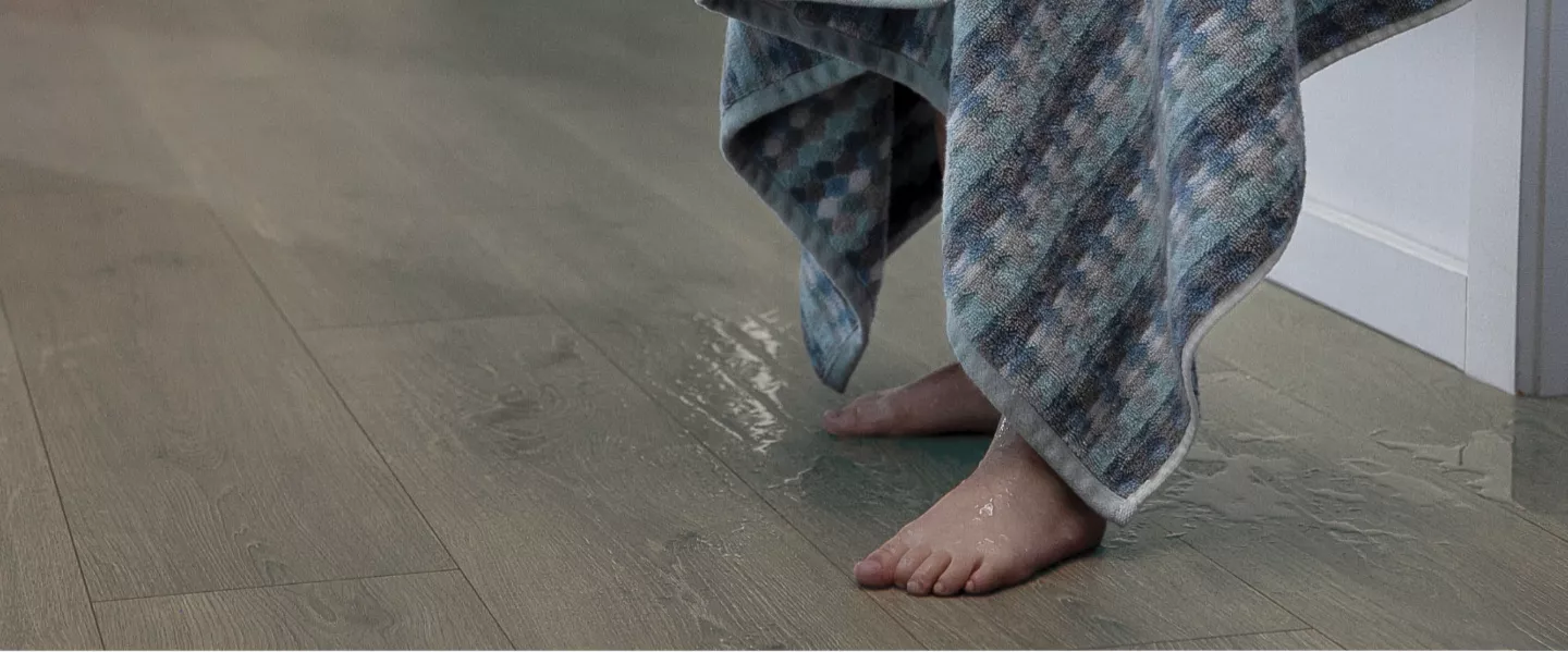 child dripping water on hardwood floors