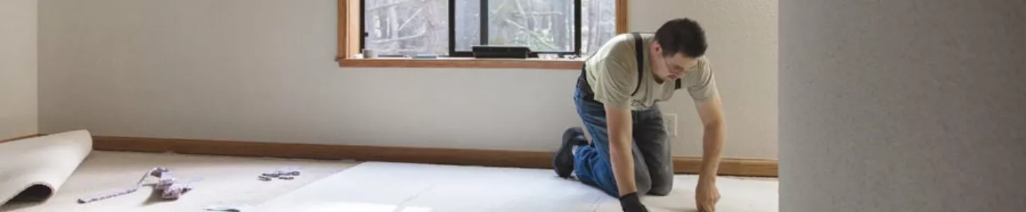 Worker installing carpet flooring