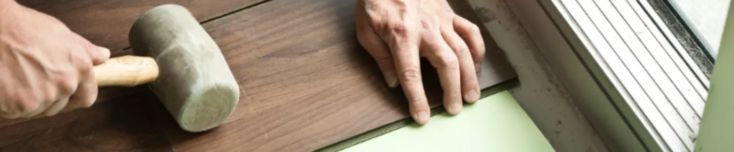 worker installing hardwood flooring
