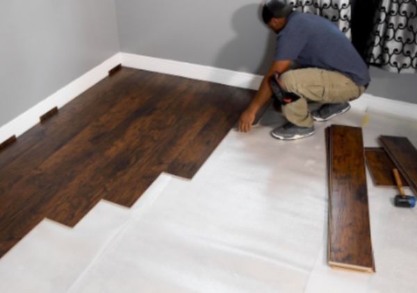 Worker installing hardwood flooring