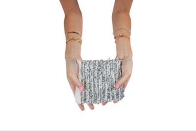 A person with a gray and white cloth in hand, highlighting the unique pattern and softness of the material.