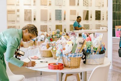 Woman signing in next to a table of donated Easter baskets during the Mohawk Group Baskets & Bunnies drive supporting Children’s Healthcare of Atlanta.