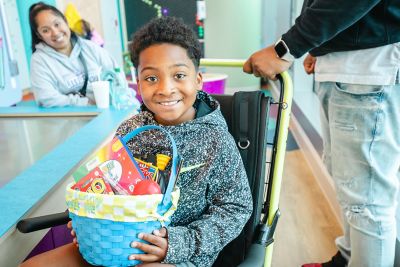 Child smiling and holding a donated Easter basket from the Mohawk Group Baskets & Bunnies drive for Children’s Healthcare of Atlanta.