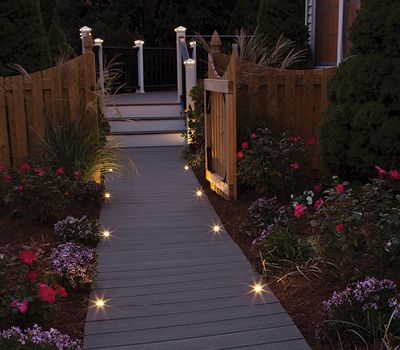 L’éclairage à DEL des marches complète la terrasse en bois de véranda Transcend et la rampe pour former un sentier éclairé dans la nuit